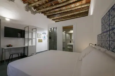 a white bedroom with a bed and a desk at Ballarooms Experience in Palermo