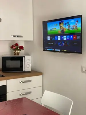 a kitchen with a microwave and a television on a wall at Luxury Royal House in Palermo
