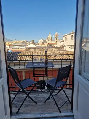 a patio with two chairs and a table on a balcony at Palermo Centro Le Cupole della Felicissima in Palermo