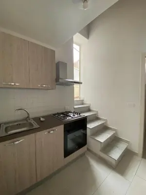 a kitchen with a stove and a sink and stairs at LA CASA DI ALISIA Palermo Centro in Palermo