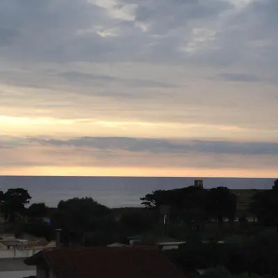 a view of the ocean at sunset from a building at Hotel Il Pirata in Cinisi