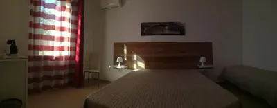 a small bedroom with a bed and a window at Aquilone in Castelluzzo
