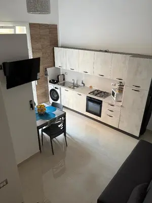 a kitchen with a table and a stove top oven at Arena Dorada apartaments Margarita in Balestrate
