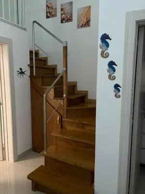 a staircase in a house with wooden steps and a railing at Arena Dorada apartaments Margarita in Balestrate
