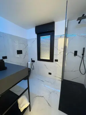 a bathroom with a shower and a sink and a window at Suit home Archimede in Palermo