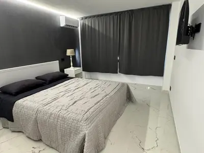 a bedroom with a bed and a large window at Suit home Archimede in Palermo