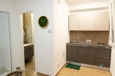 a kitchen with a sink and a clock on the wall at ESSE Homes Sant Elia in Santa Flavia