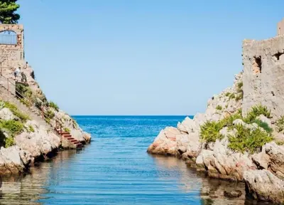 a large body of water next to some rocks at ESSE Homes Sant Elia in Santa Flavia