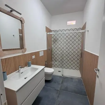 a bathroom with a sink and a toilet and a mirror at Cocciu d'amuri a casa in Terrasini
