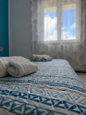 a bed with towels on it with a window at 