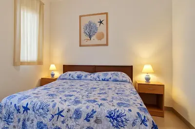 a bedroom with a blue and white bed and two lamps at Stella Del Mare in Castellammare del Golfo