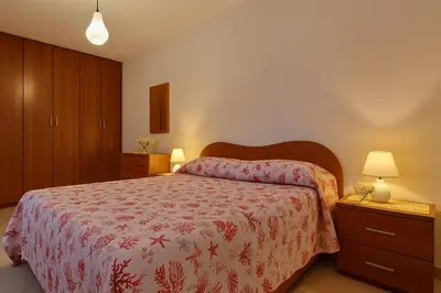 a bedroom with a bed with a red bedspread at Stella Del Mare in Castellammare del Golfo