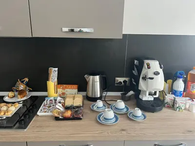 a counter with plates of food and a coffee maker at kalispera in Cinisi