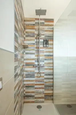 a shower in a bathroom with wooden tiles at kalispera in Cinisi