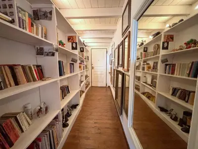 a hallway with white shelves filled with books at Ciak a Ballarò in Palermo