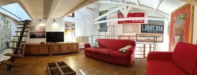 a living room with a red couch and a television at Ciak a Ballarò in Palermo
