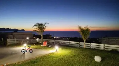 a bike parked on a sidewalk next to the ocean at night at Villa Mare Luna in Balestrate