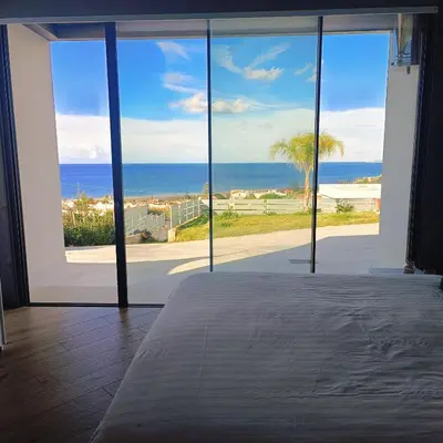a room with a large window with a view of the ocean at Villa Mare Luna in Balestrate
