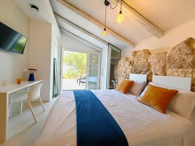 a bedroom with a large white bed and a desk at Villa Teleffio in Castellammare del Golfo