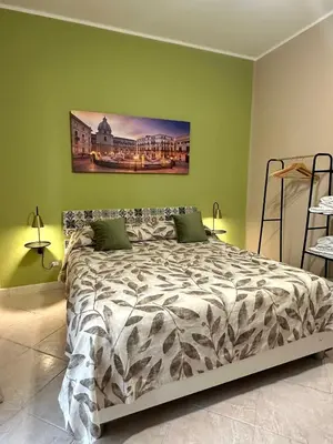 a bedroom with a bed in a green wall at Victoria Apartment in Palermo