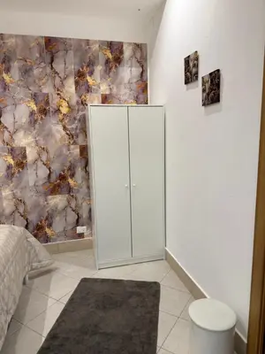a bedroom with a white cabinet next to a wall at La Casa di Tiche in Palermo