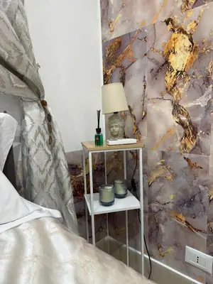 a bedroom with a bed and a table with a lamp at La Casa di Tiche in Palermo