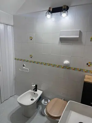 a white bathroom with a toilet and a sink at La casa di Tiche in Palermo