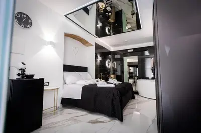 a bedroom with a large bed and a mirror at Palermo Luxury Rooms White in Palermo