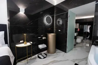a hotel room with a black wall and a bathroom at Palermo Luxury Rooms White in Palermo