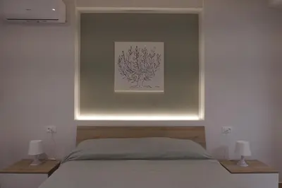 a bedroom with a bed with a picture on the wall at Le Stanze del Massimo in Palermo