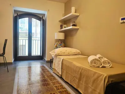 a bedroom with two beds and a door with a window at Il rifugio del Capo in Palermo
