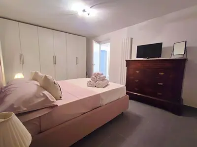 a bedroom with a bed with a dresser and a television at Il rifugio del Capo in Palermo