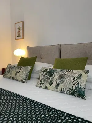 a bed with three pillows on it with at Alvorada Rooms in Palermo