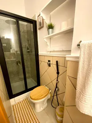 a bathroom with a toilet with a glass shower at Alvorada Rooms in Palermo