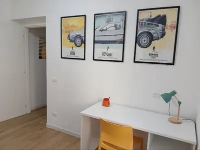 a white desk with four pictures on a wall at The Junction in Palermo