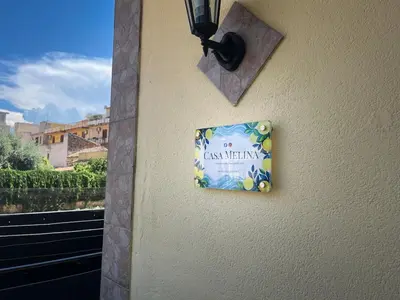 a sign on the side of a building with a window at Casa Melina in Palermo