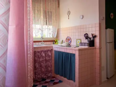 a pink and blue kitchen with a sink and a window at Casa Melina in Palermo