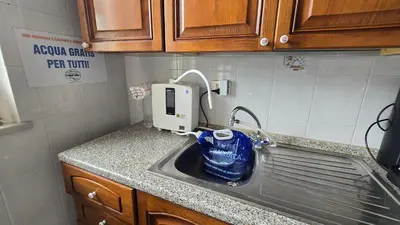 a kitchen sink with a bottle of water in it at Cottage I Sollazzi in Palermo