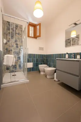 a bathroom with two toilets and a glass shower at Borgo di Mare in Palermo