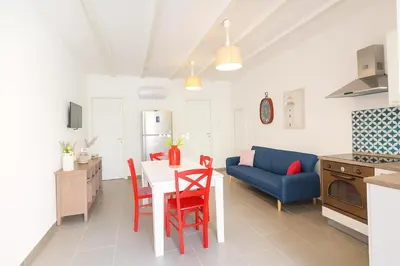 a kitchen and living room with a table and a blue couch at Borgo di Mare in Palermo
