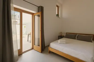 a bedroom with a bed and a sliding glass door at Borgo di Mare in Palermo