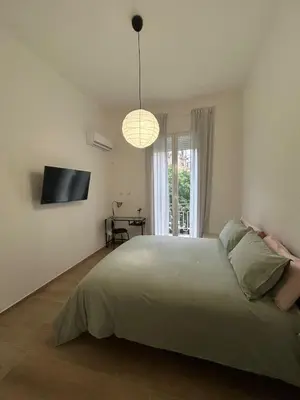a bedroom with a large bed and a television at Iazzu Apartament in Palermo