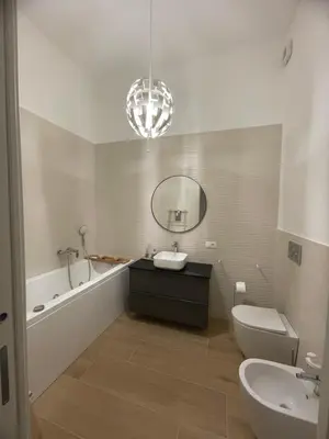 a bathroom with a sink and a tub and a mirror at Iazzu Apartament in Palermo