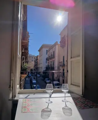 two wine glasses sitting on a table in front of a window at Ballaria Pop Art in Palermo