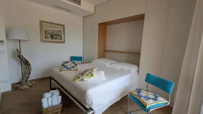 a bedroom with a bed and a blue chair at Mondello D'Amare in Palermo