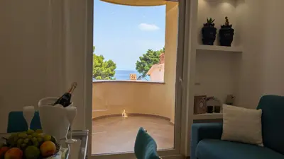 a living room with a view of the ocean through a window at Mondello D'Amare in Palermo
