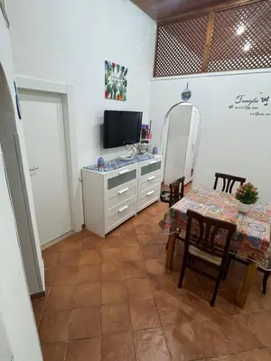 a living room with a table and a television at Casa la Fenice in Palermo
