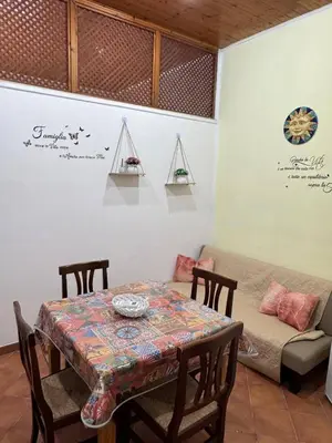 a table and chairs and a couch in a room at Casa la Fenice in Palermo