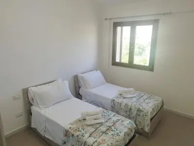 a bedroom with two beds and a window at La Marina Pool Villa in Trappeto