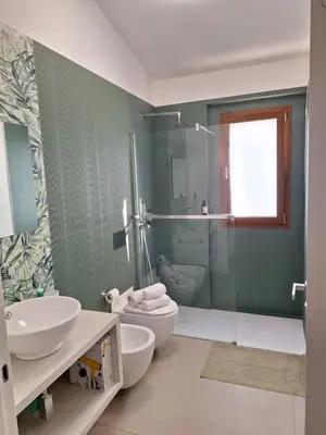 a bathroom with two sinks and a toilet and a shower at La Marina Pool Villa in Trappeto